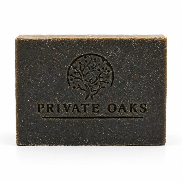 A rectangular dark brown bar of soap with a textured finish, embossed with a tree logo and the brand name 'PRIVATE OAKS' on the front, set against a plain white background.