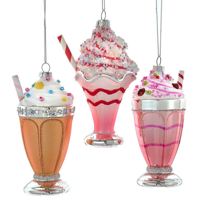 Decorative milkshake ornaments with colorful toppings on a white background