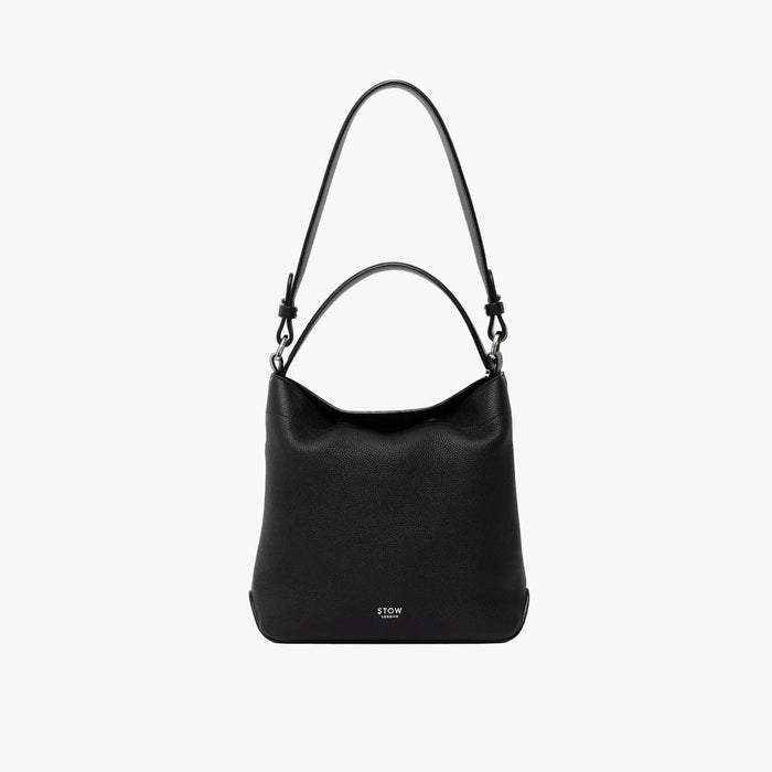 STOW London's Midi Curve and detachable shoulder strap and top handle in Black leather on a light grey background featuring silver hardware and details