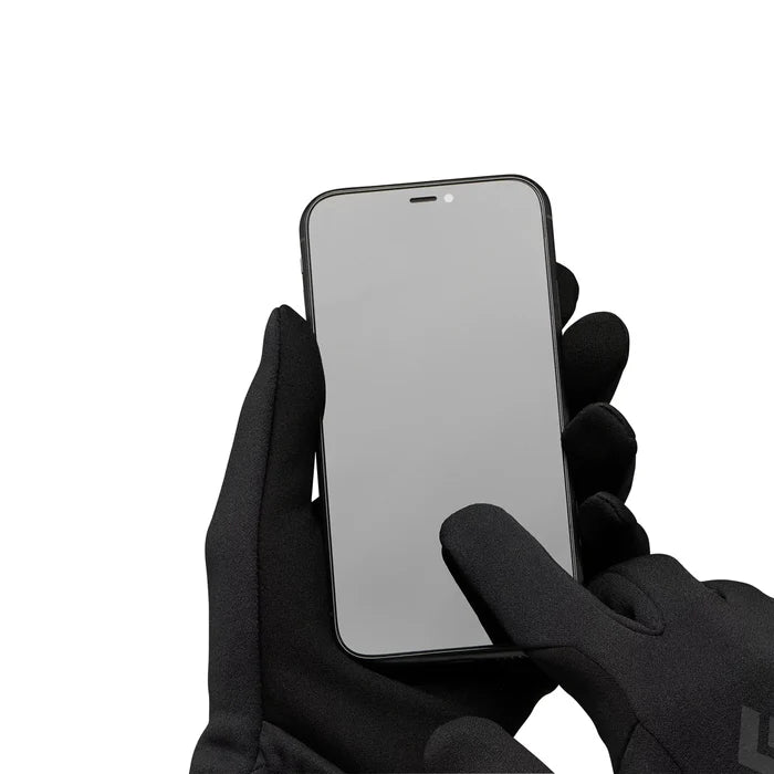 Hand wearing a black glove holding a smartphone with a reflective screen on a white background