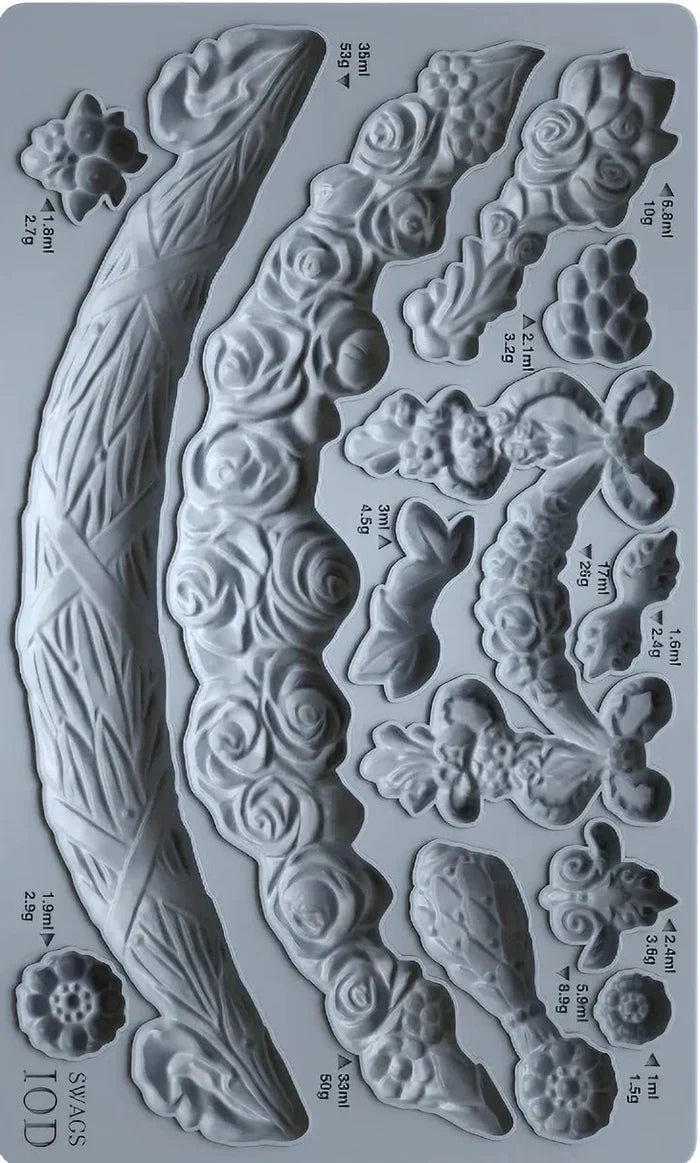 Metallic mold with various floral and leaf designs on a gray background