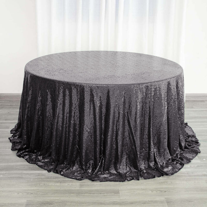 Black sequin tablecloth draped over a round table.