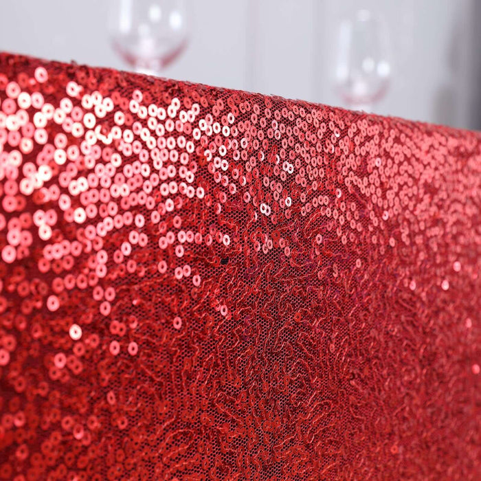 Red sequin tablecloth with sparkling texture.