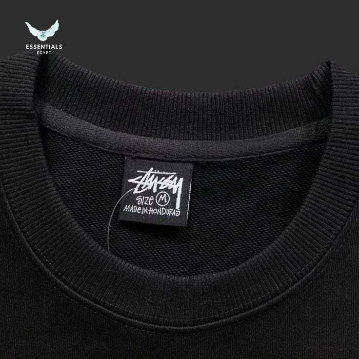 Black sweater with a visible brand label on a dark background