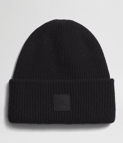 Black beanie with a brand patch on a light gray background