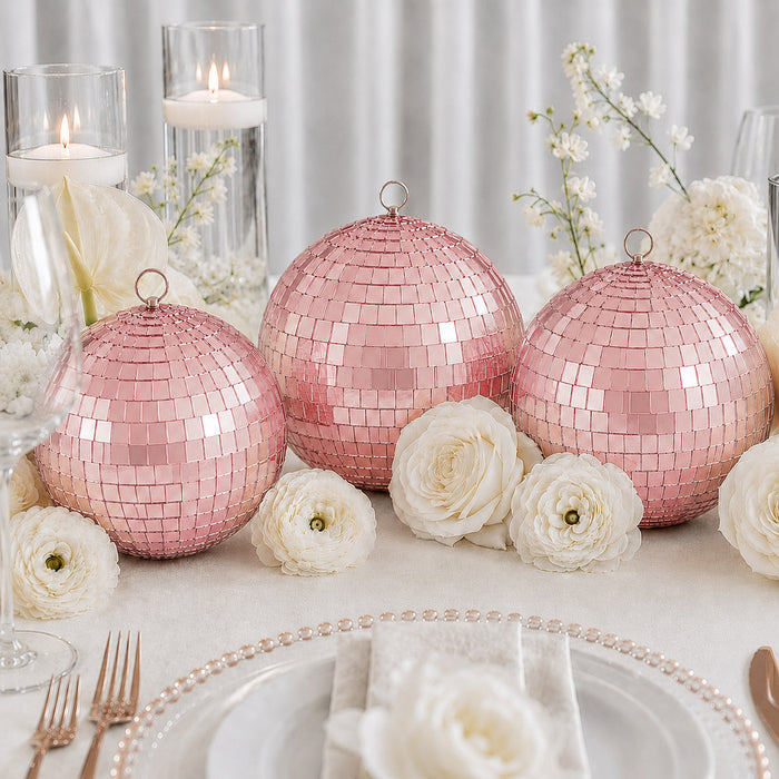 Pink mirrored disco ball table decor with white flowers and candlelight