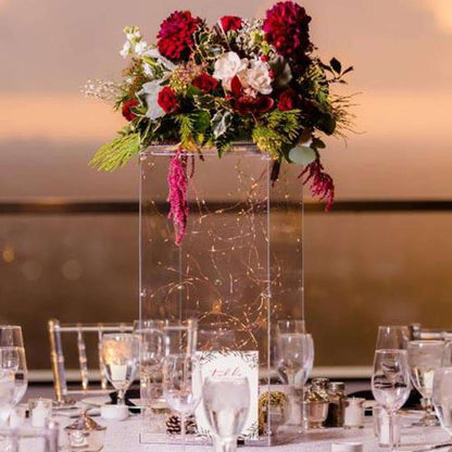 Elegant floral centerpiece with red and white blooms in a glass vase.