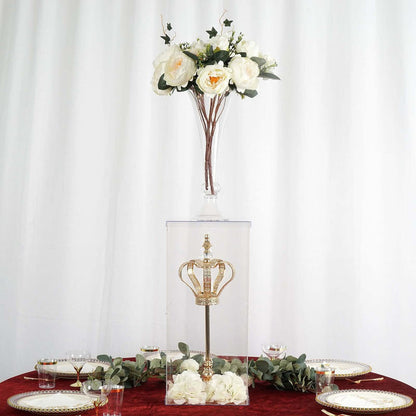 Crown display under glass with flowers on top, set on a dining table.
