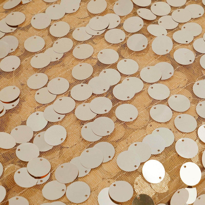 Gold circular sequins on a textured beige fabric background. #whtbkgd