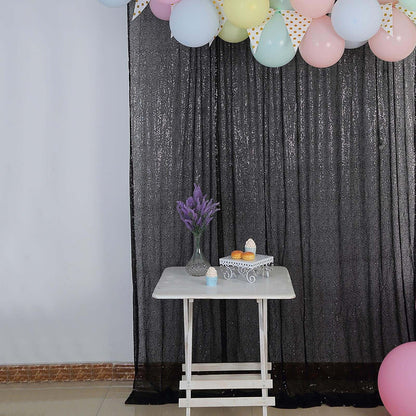 Decorative table with flowers and treats, set against a black backdrop.
