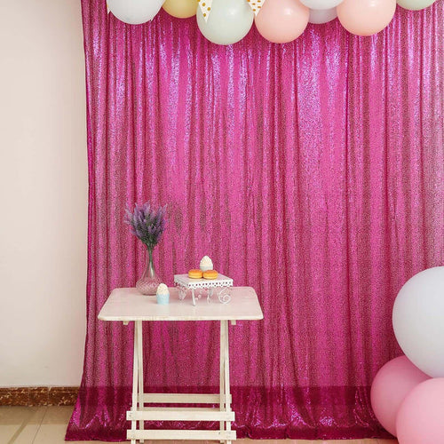 Colorful balloon backdrop with a sparkling pink curtain and a decorative table setting.