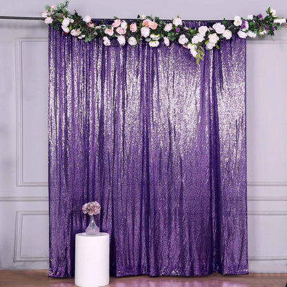 Purple sequin backdrop with floral arrangement for events or photography.