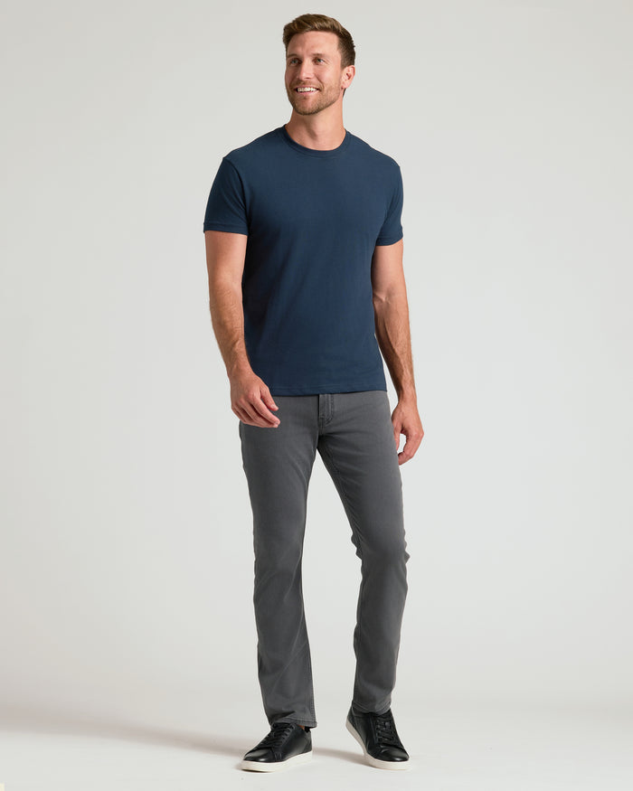 Man in Classic Crew Neck 6-Pack attire, navy T-shirt, gray pants.