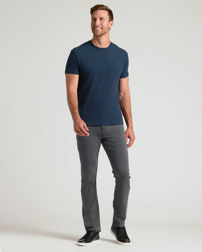 Man in Classic Crew Neck 6-Pack attire, navy T-shirt, gray pants.