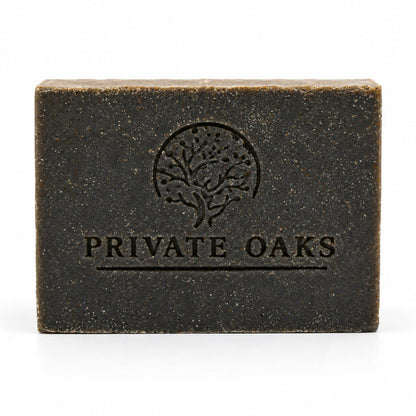 A rectangular dark brown bar of soap with a textured finish, embossed with a tree logo and the brand name 'PRIVATE OAKS' on the front, set against a plain white background.