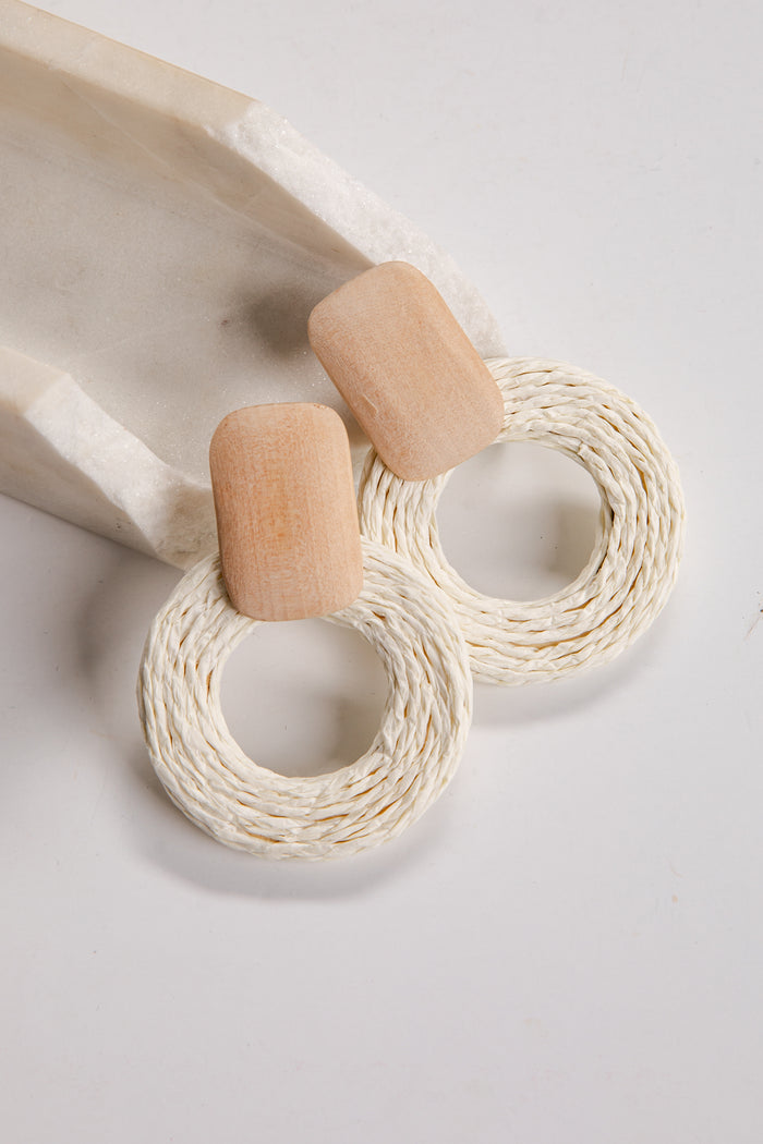 Wooden and woven earrings on a light background