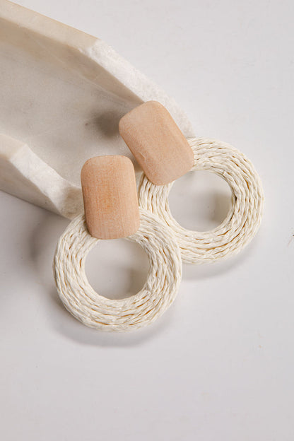 Wooden and woven earrings on a light background