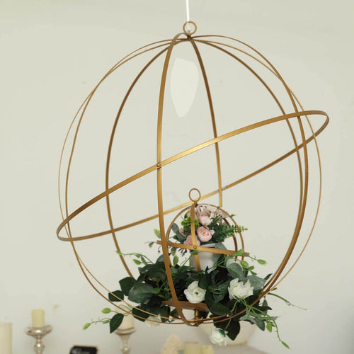 Gold geometric hanging planter with flowers and greenery.