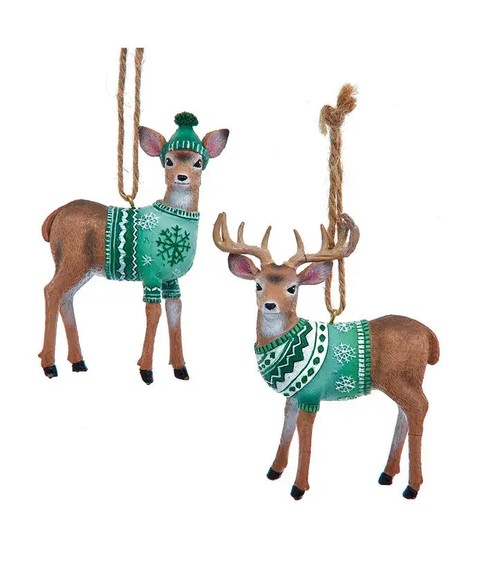 Two deer ornaments wearing green sweaters with snowflake patterns on a white background.