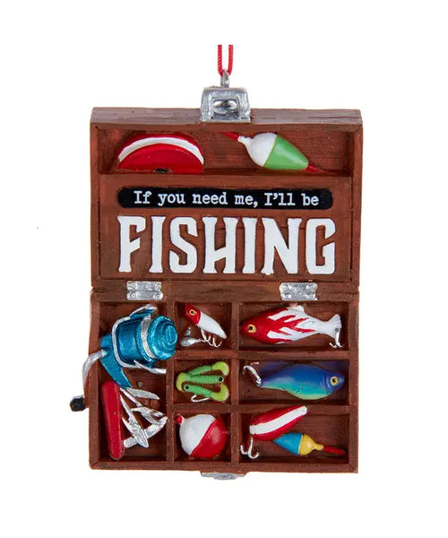 Wooden fishing tackle box with colorful fishing lures and a sign inside.