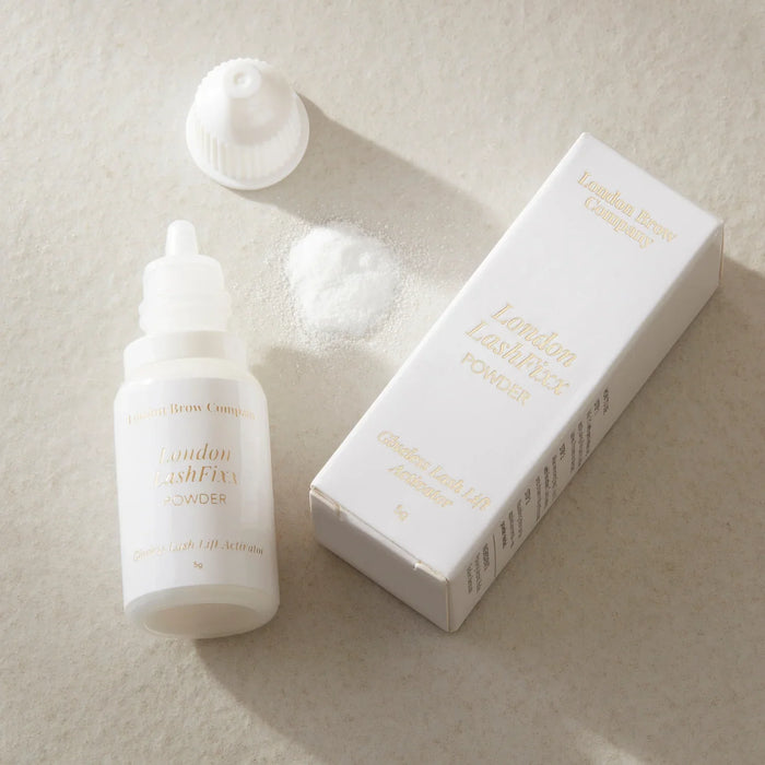White lash lifting glue powder product bottle and packaging on a beige background