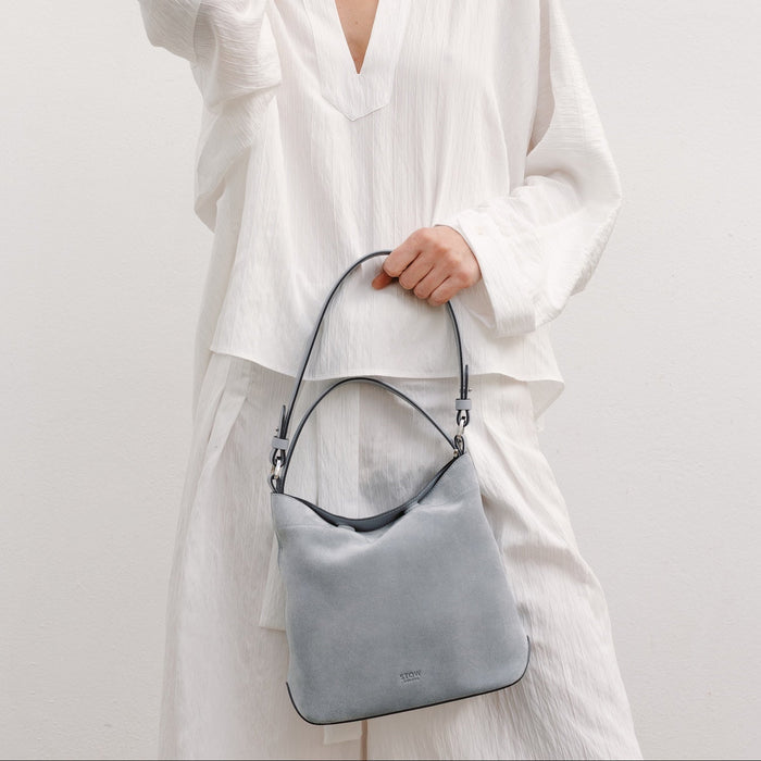 Model with STOW London's Midi Curve in Misty Blue suede featuring the detachable shoulder strap