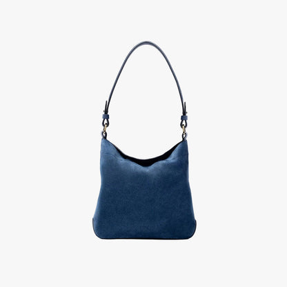 STOW London's Midi Curve in Navy suede leather on a light grey background featuring the detachable shoulder strap with gold hardware and details