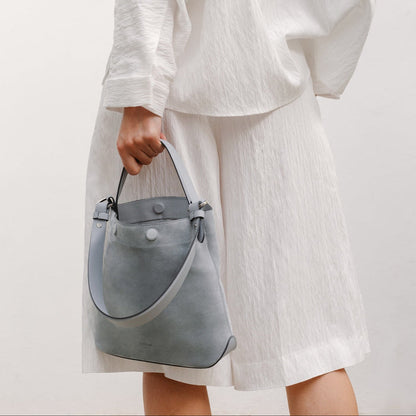 Model with STOW London's Midi Curve in Misty Blue suede featuring the detachable shoulder strap