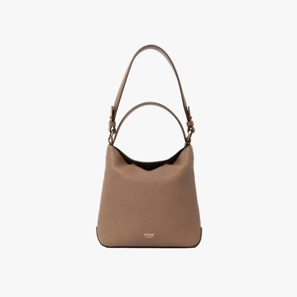 STOW London's Midi Curve and detachable shoulder strap in Mocha leather on a light grey background with top handle out featuring gold hardware and details