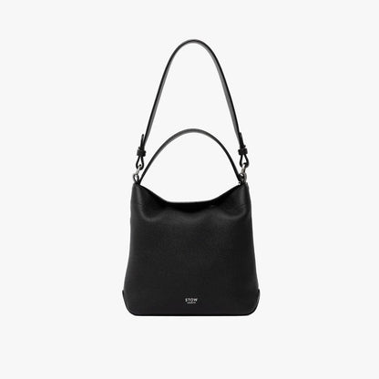 STOW London's Midi Curve and detachable shoulder strap and top handle in Black leather on a light grey background featuring silver hardware and details