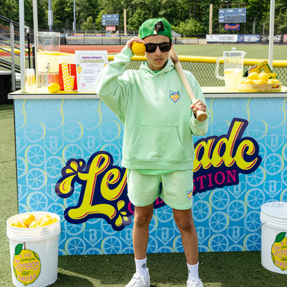 Youth model wearing green youth shorts with "Lemonade" design