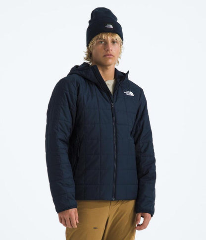 Person wearing a navy blue jacket with a hood on a white background