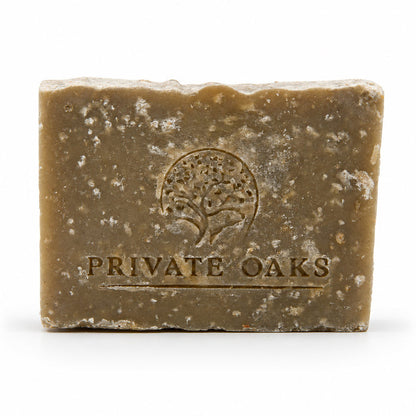 A rectangular bar of handmade soap in a warm brownish-tan color with white speckles, embossed with a tree logo and the brand name 'PRIVATE OAKS' on a white background.