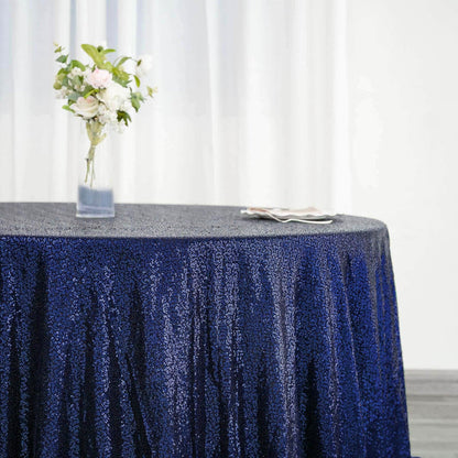 Navy sequin tablecloth draped over a round table with floral centerpiece