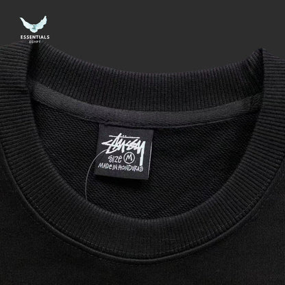 Black sweater with a visible brand label on a dark background