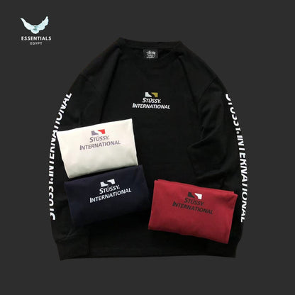 Black sweatshirt with Stussy International branding and three pouches in white, navy, and red on a dark background.