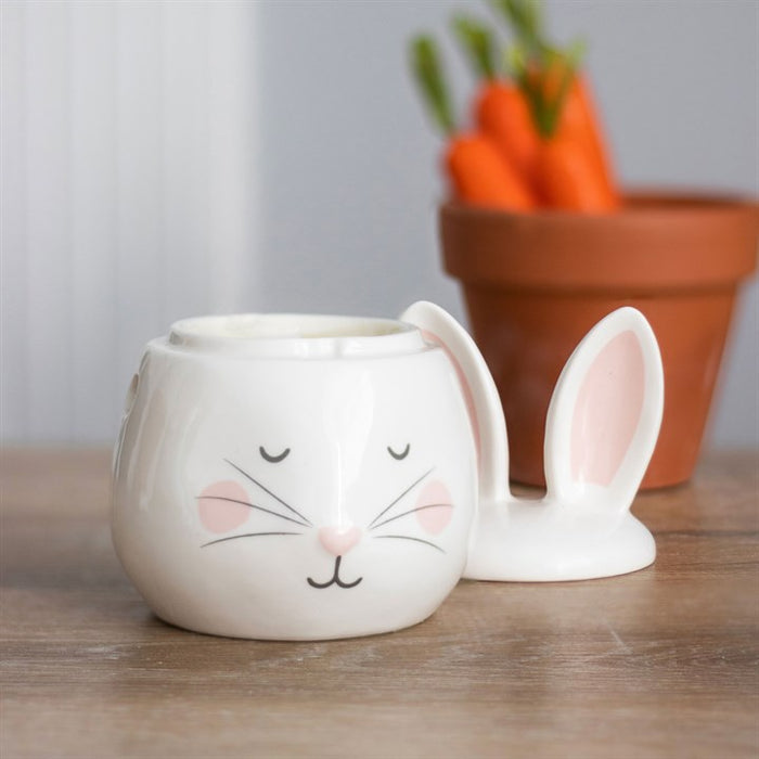 bunny oil burner displayed with lid placed beside it in relaxed home setting