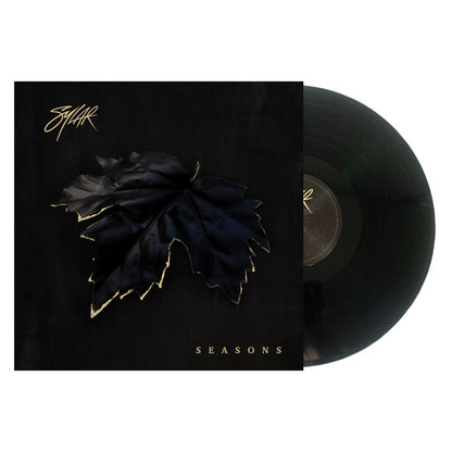 A vinyl record partially slides out of its cover. The Sylar album artwork displays a large black leaf with gold edges on a dark background, SYLAR in stylized text at the top left, and SEASONS in gold letters at the bottom.