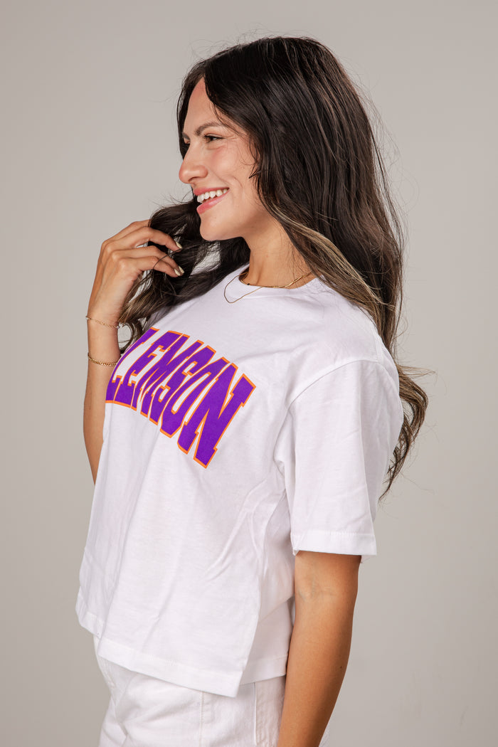 Woman wearing a white t-shirt with purple text on a gray background