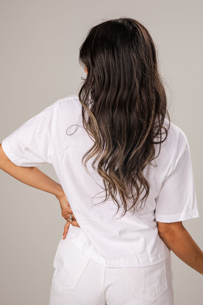 Person wearing a white t-shirt and pants against a plain background