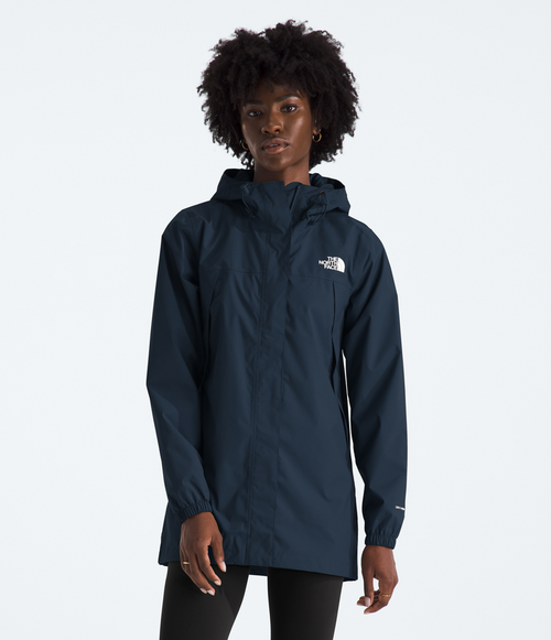 Person wearing a navy blue raincoat with a brand logo on a white background